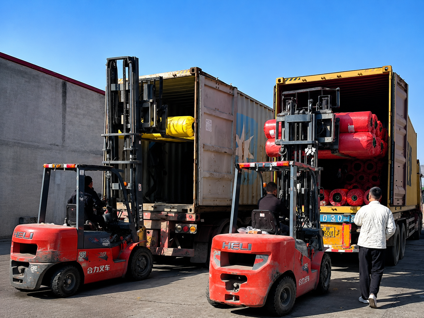 Artificial grass rolls moved by forklift during container loading