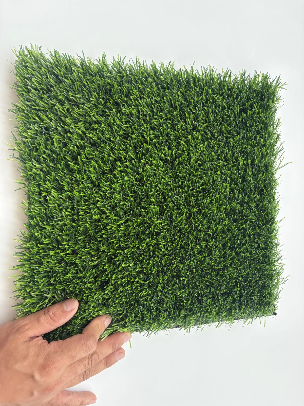 Commercial landscape artificial turf hand scale and texture view